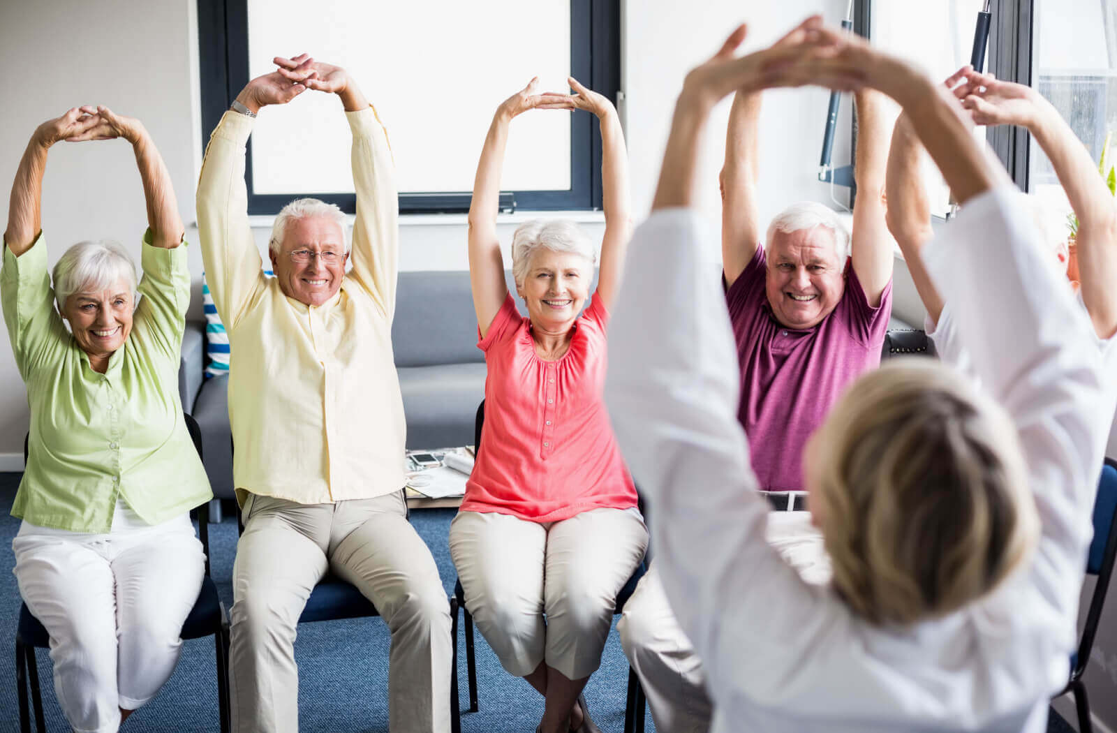 a group of seniors doing exercises while seated