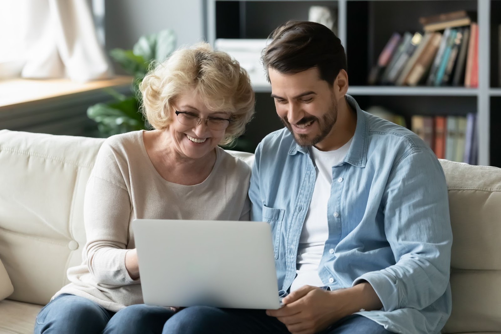 a senior woman and her younger son look at assisted living options on a laptoop