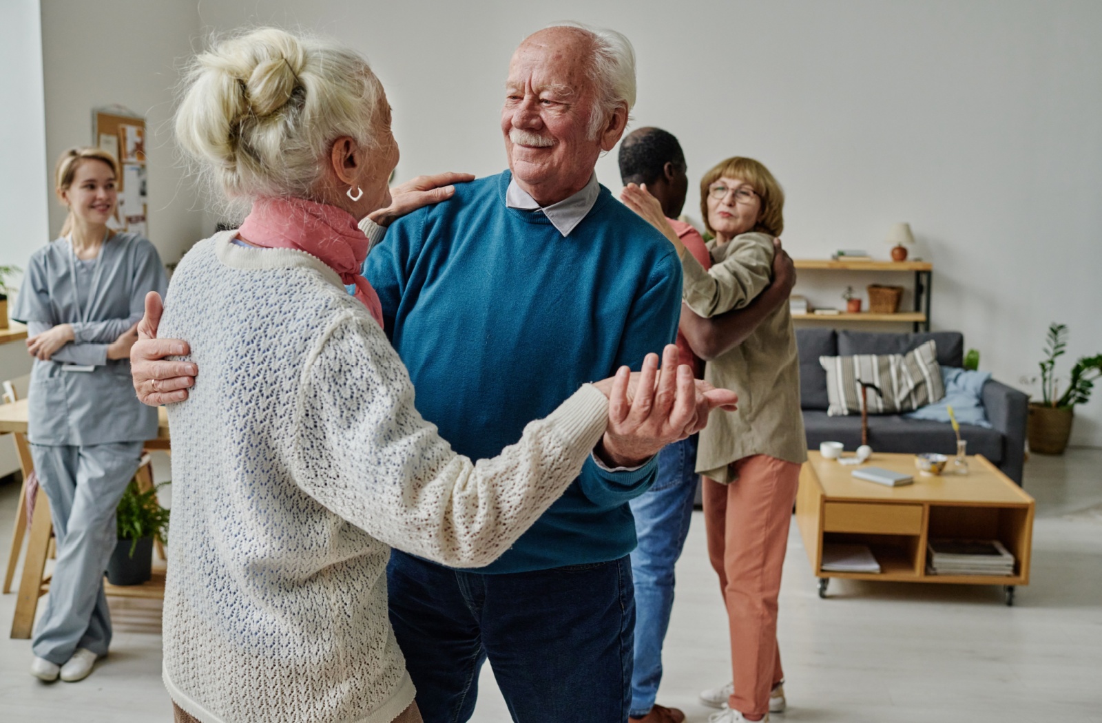 A pair of older adults smiling at one another during a dance class in senior living.
