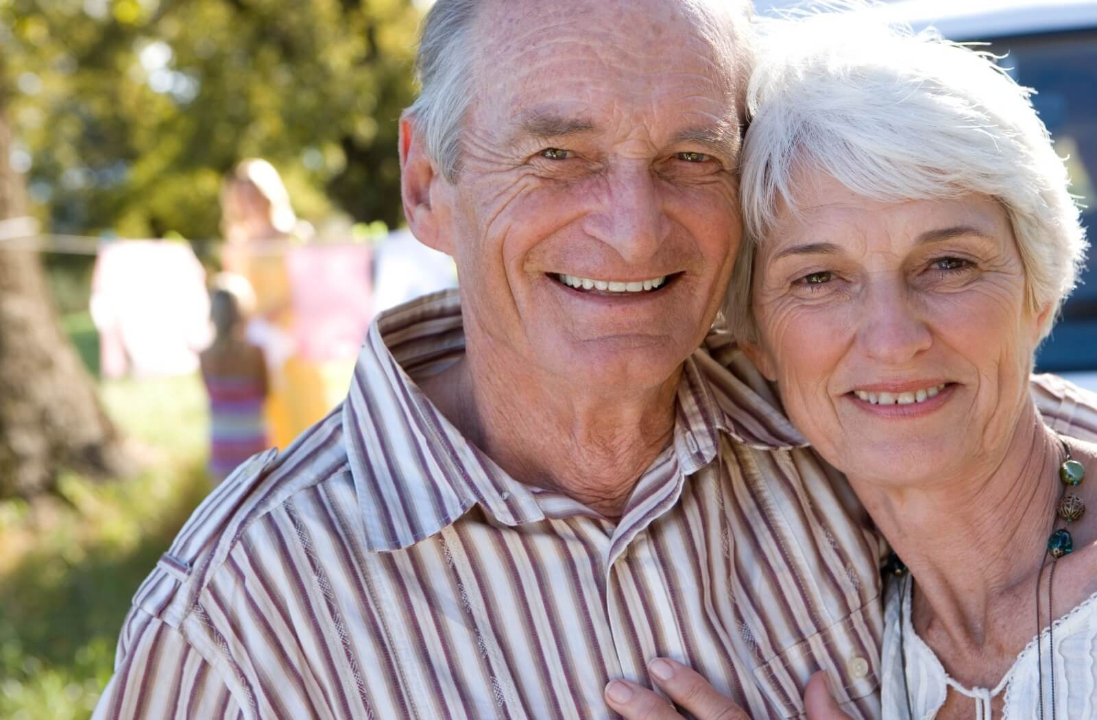 An older couple embraces while enjoying their day trip around Mobile, AL.
